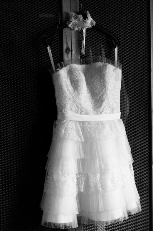 the wedding dress is hanging from the closet