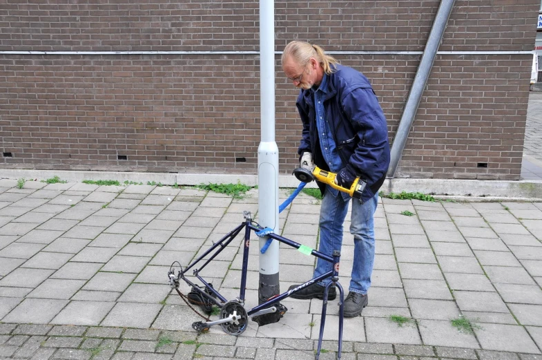 a man is installing a lightpost at a street