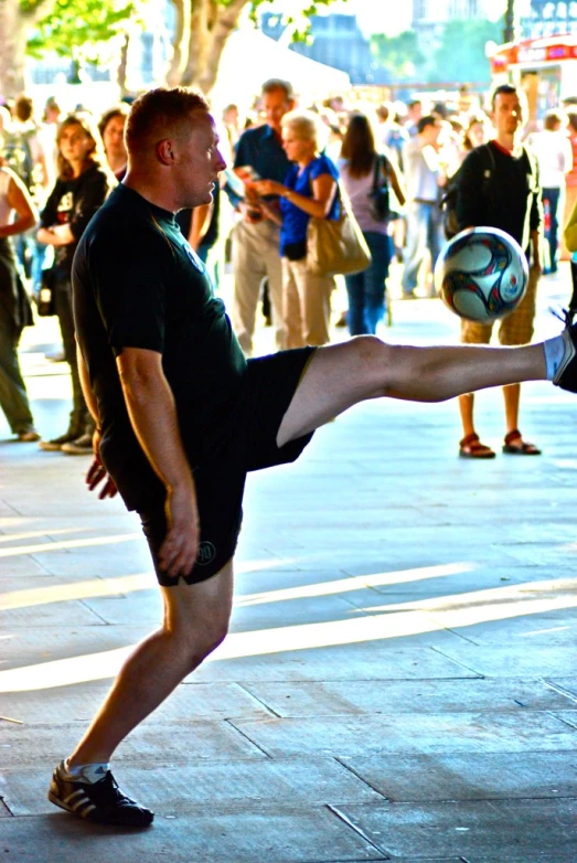 a man is kicking the ball while people look on