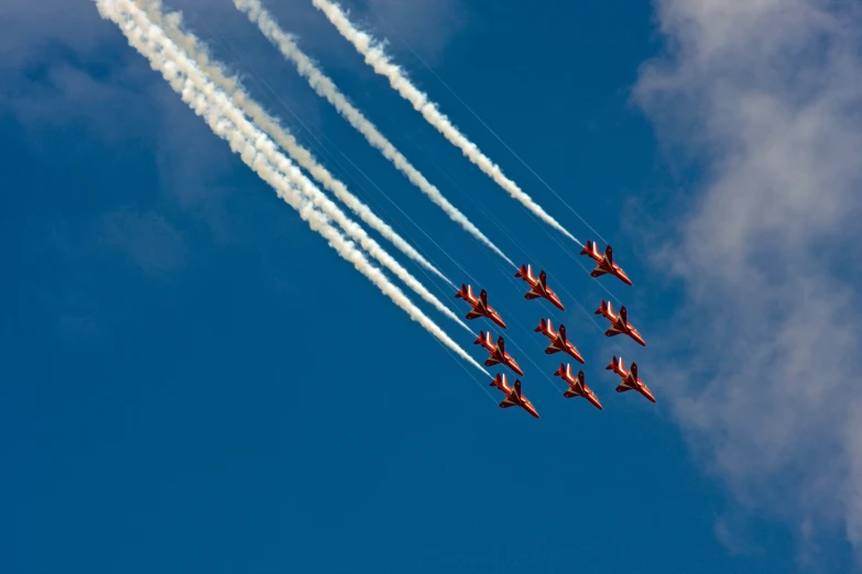 red and white air planes are flying in formation