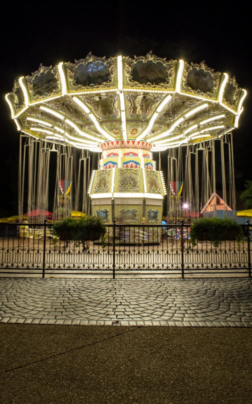 a carousel ride sitting on top of a night time fair