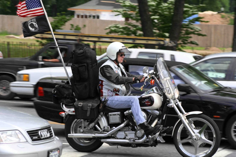 the man is riding his motorcycle with a flag