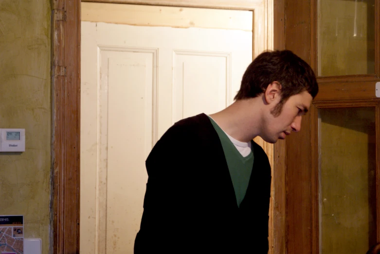 a young man standing in front of an open door