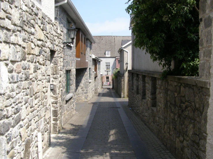 an empty street is lined with narrow cobblestone buildings