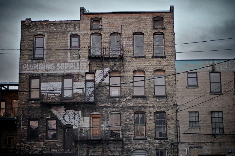 the back side of an abandoned building with broken windows