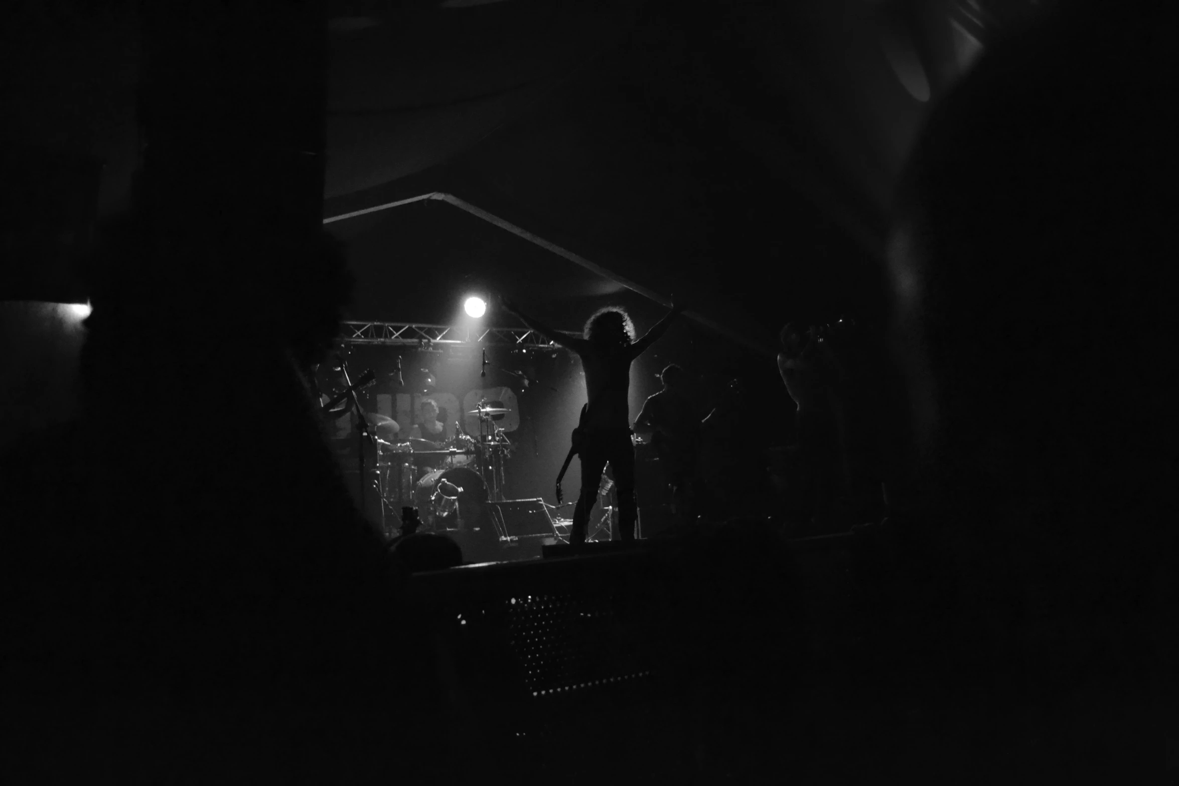 a person on stage in the dark at a concert