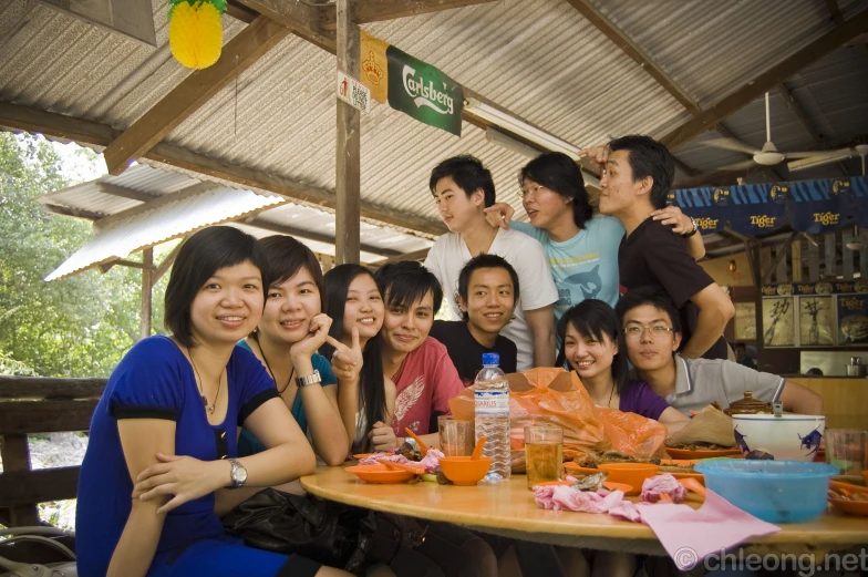 group of people sitting at a table eating and smiling