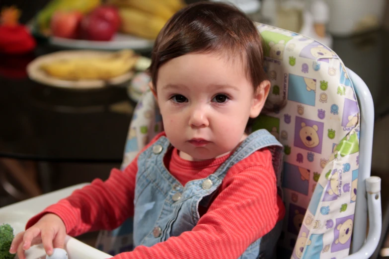 an adorable little  in a booster seat