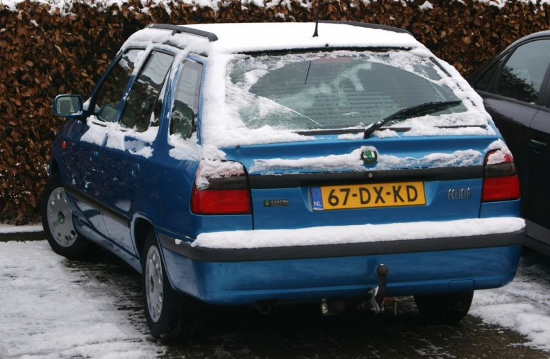 an suv covered in snow next to two vehicles