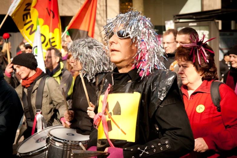 a man in costume carrying a drum in front of people