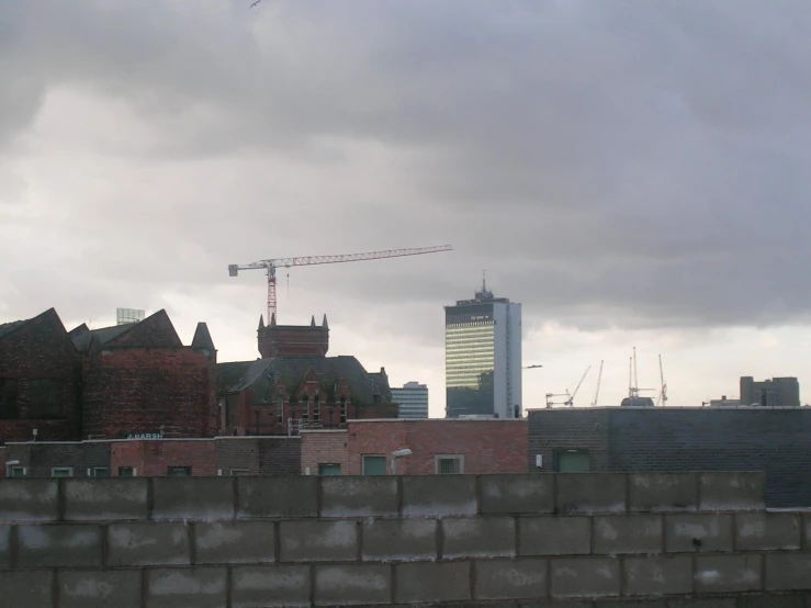 a building with cranes on top of it under a cloudy sky