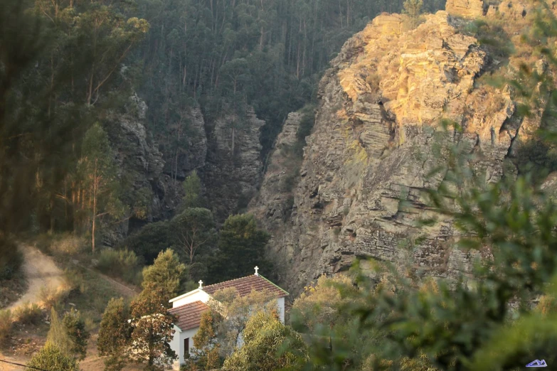 a large house perched on a mountain near trees