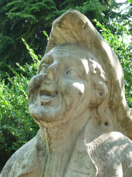 a statue with a large hat on it next to some trees