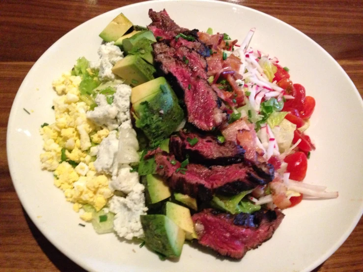 a white plate topped with meat and vegetables