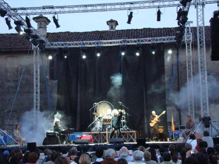 some band playing in front of a large crowd