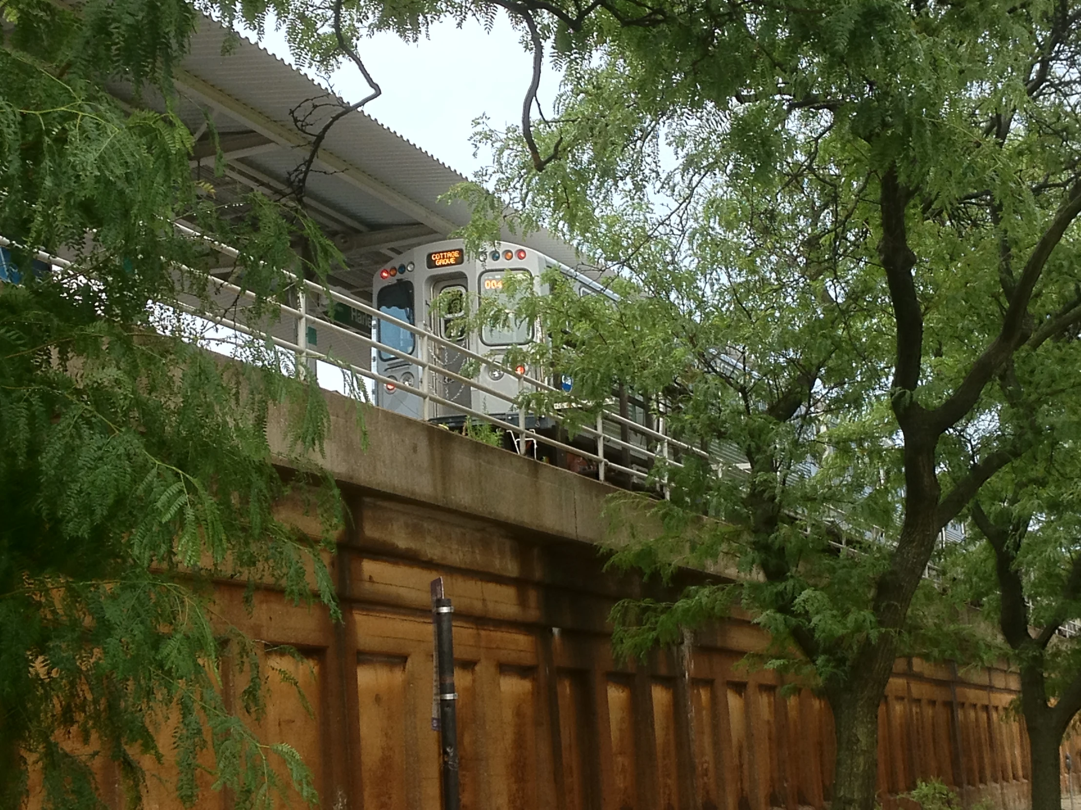 a train going over the bridge that crosses the street