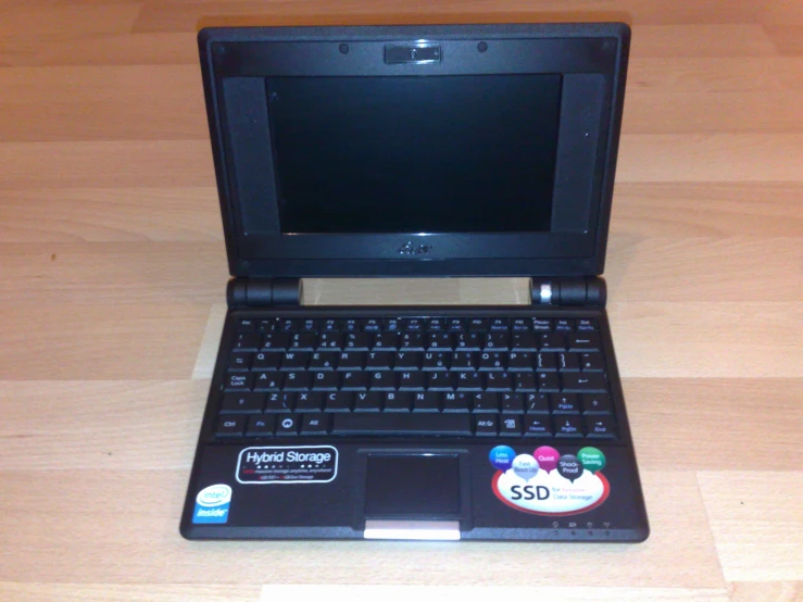 a laptop with some stickers on it sitting on a desk