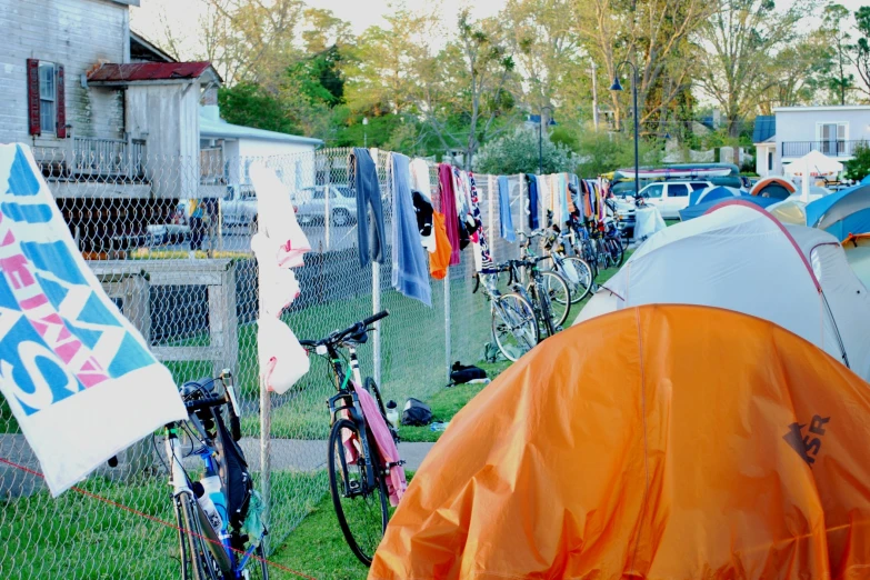 a row of tents in front of cars and bicycles