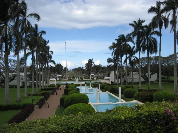 a large garden with fountains and bushes in it