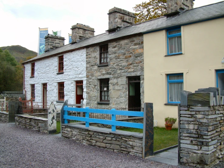 an old stone building that is painted light blue