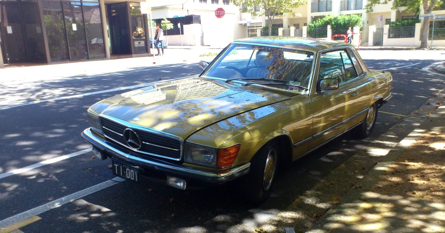 an old rusty mercedes is parked on the street