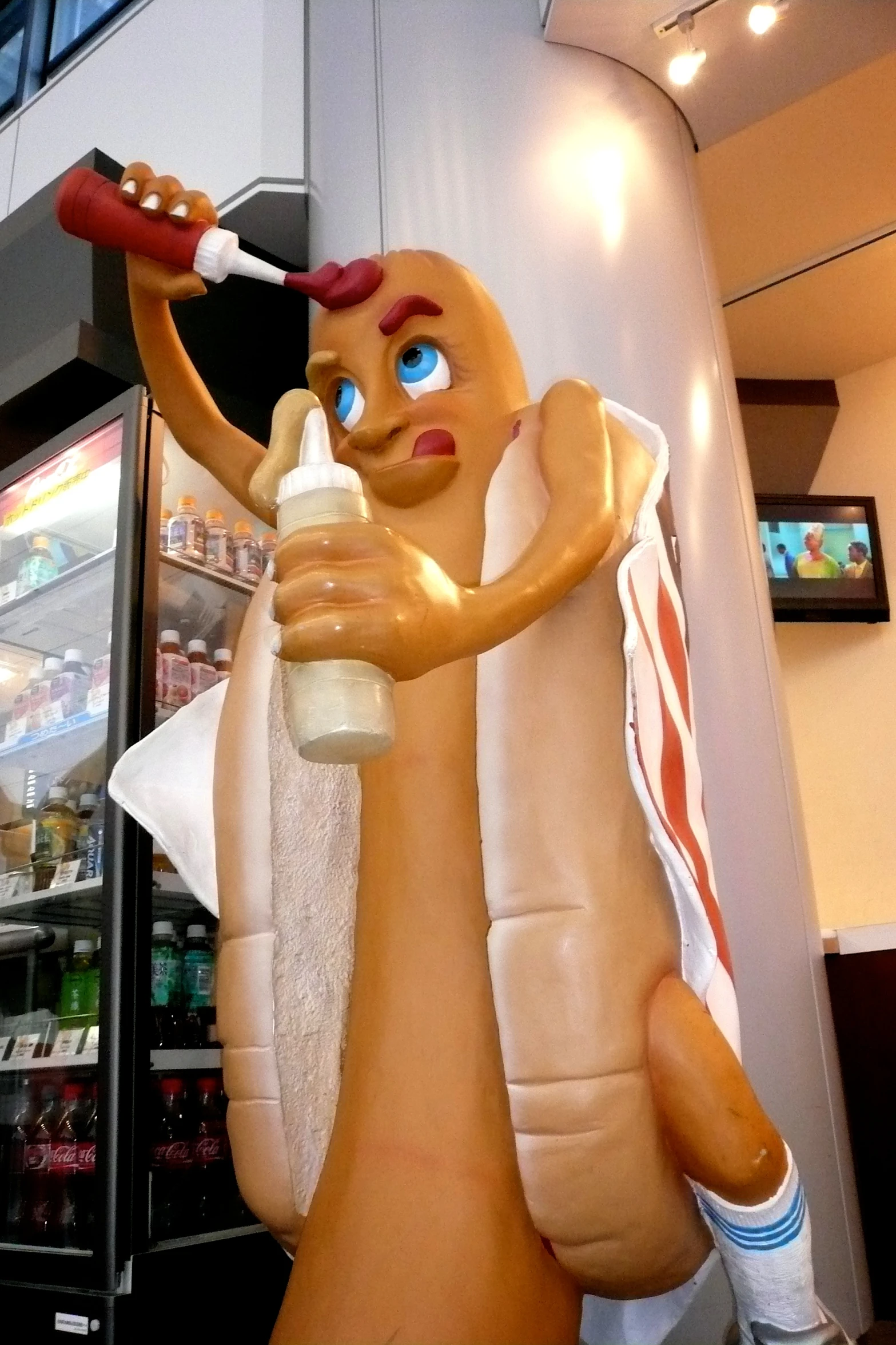 a large life - like statue of a  dog with a towel on it's arms and neck is holding a bottle with another tube