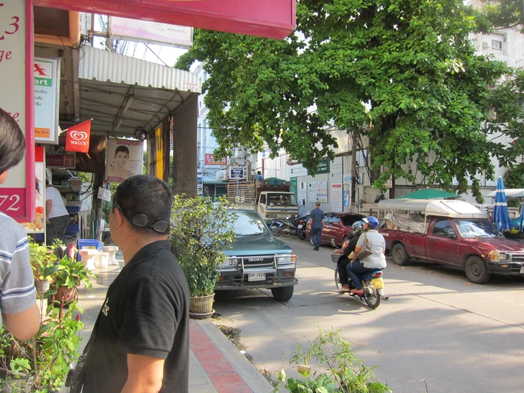 people riding a scooter down a city street