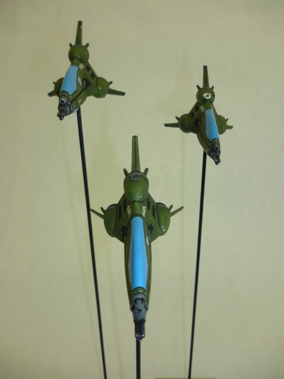 three toy planes with long poles attached to them