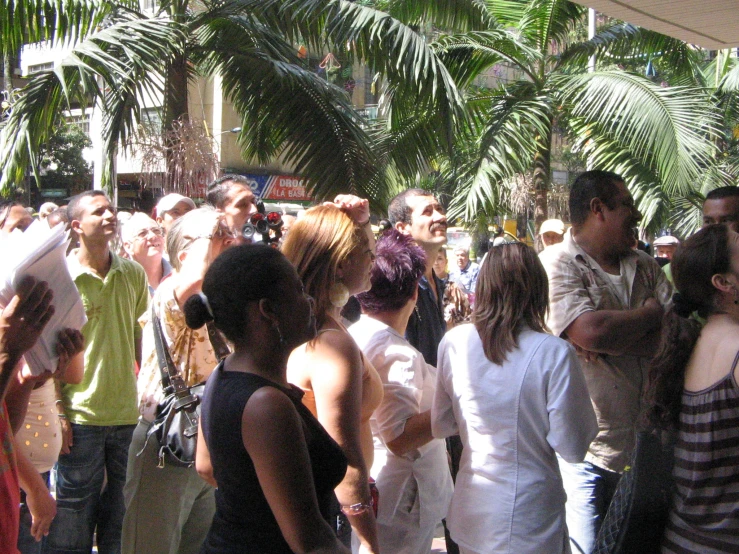 a group of people walking down a street in front of trees