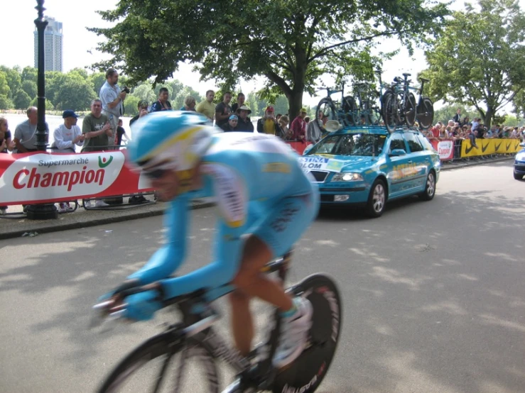 a bicyclist races past a passing car