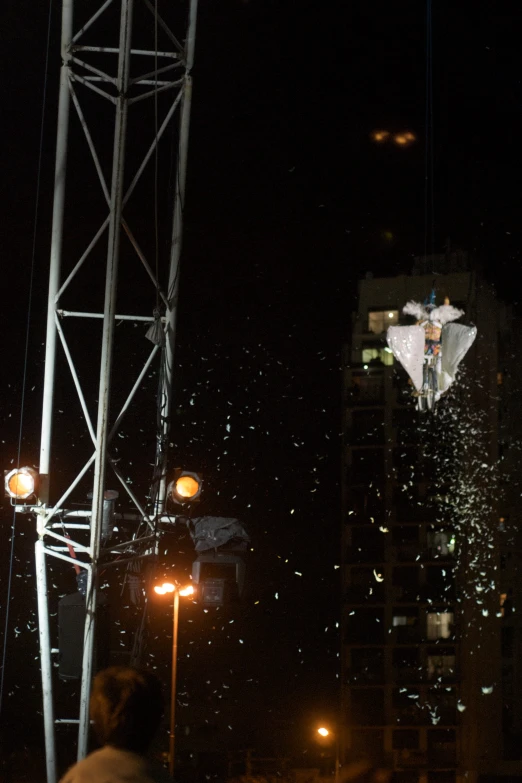 the people are standing under the umbrella in the dark