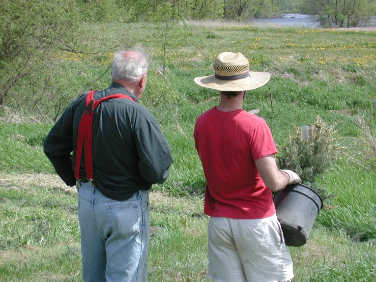 two men wearing hats in the middle of the grass