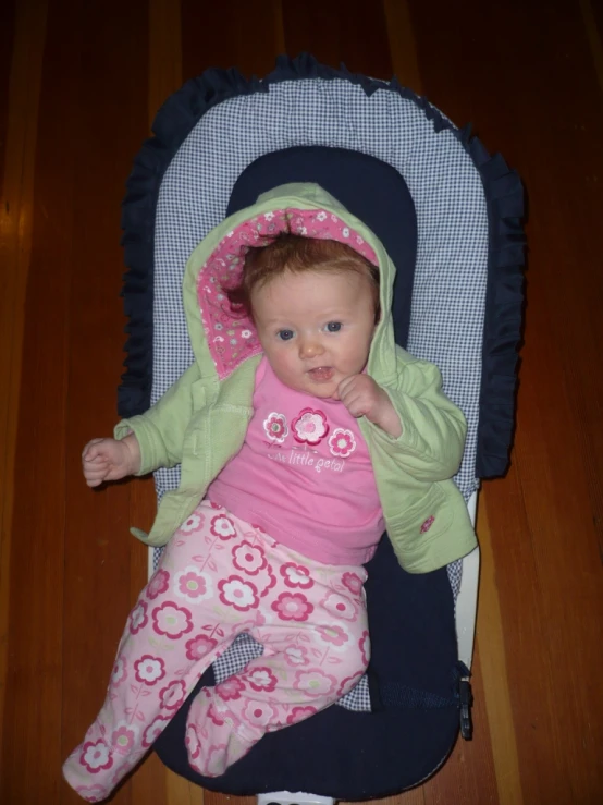 baby in pink sits in her car seat