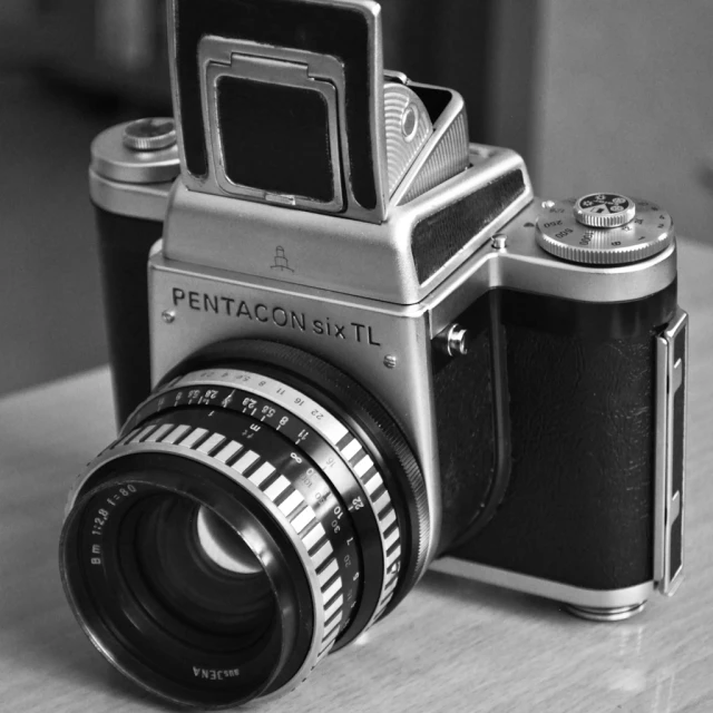 an old film camera with a small flash lens on a table