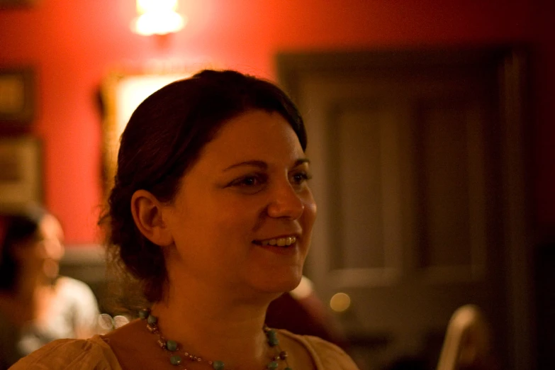 a woman sitting in a chair with a necklace on