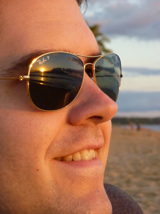 the man is wearing some glasses on the beach