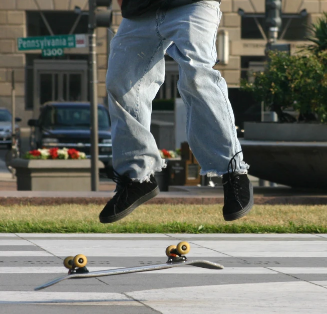 a man jumping over a skateboard on a sidewalk