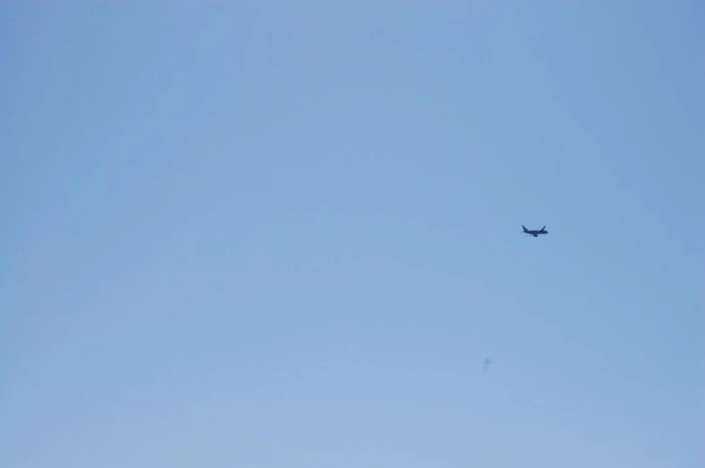 an airplane is flying through the blue sky