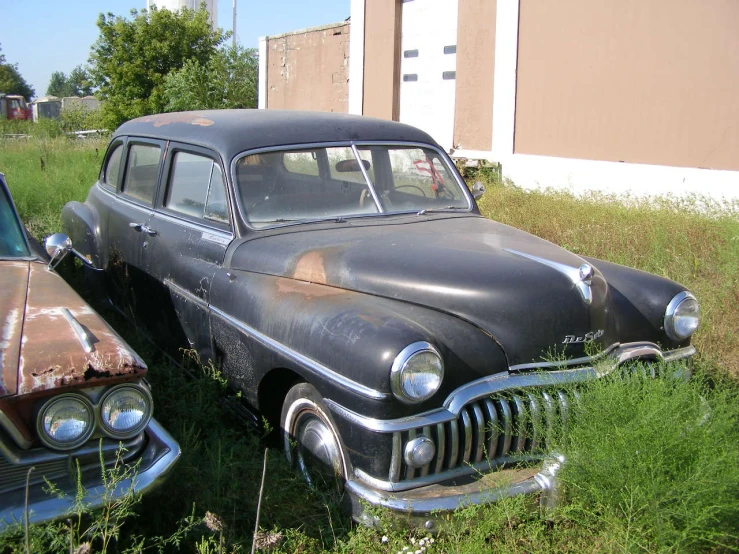 old cars parked side by side in grass