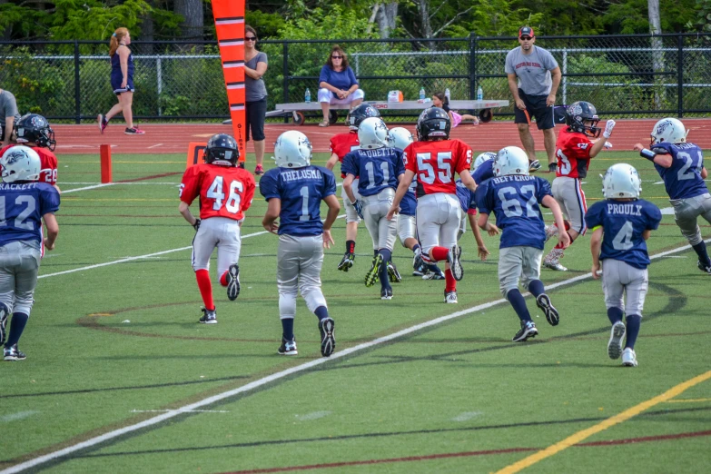 several children playing on the field with some one running