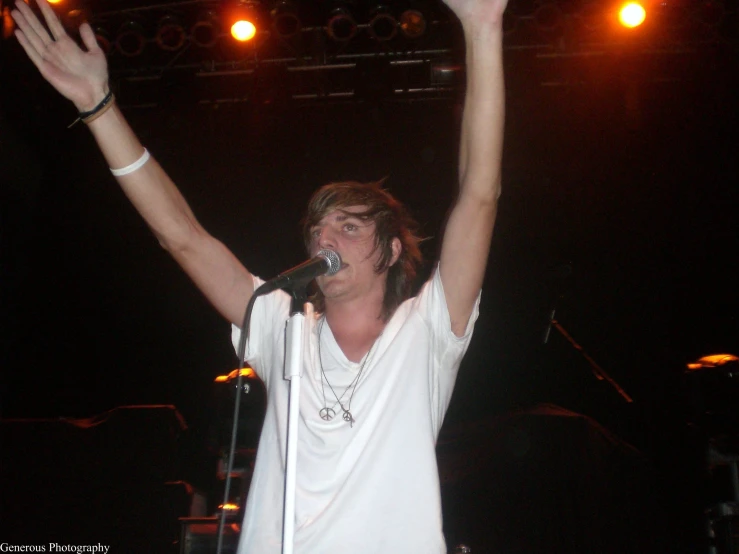 a male in white shirt and hat on stage