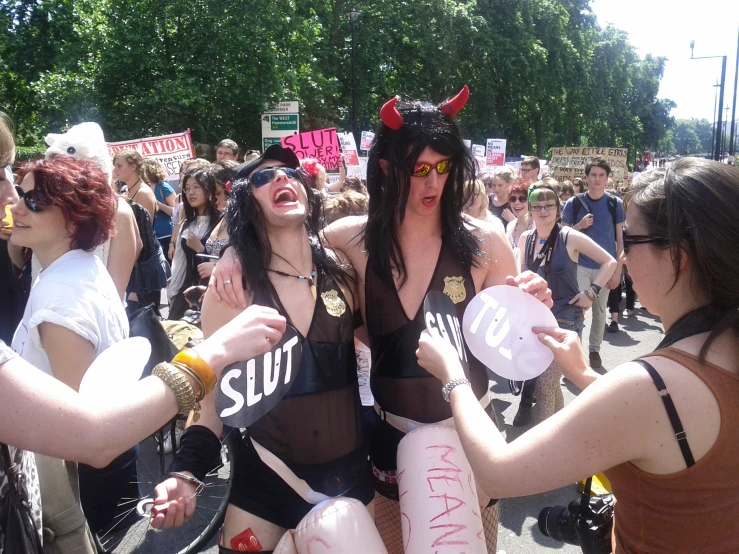 a group of young women hold signs on the street