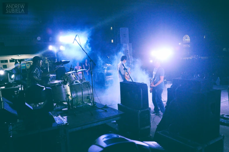 a group of men standing on a stage playing instruments