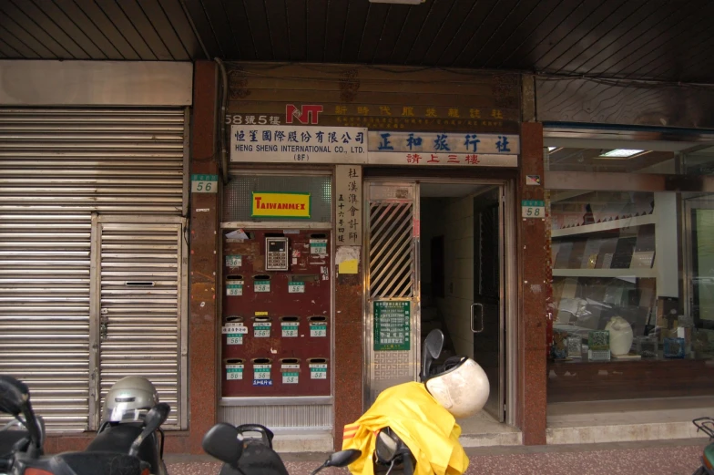 the front entrance of a chinese business with scooters parked in front