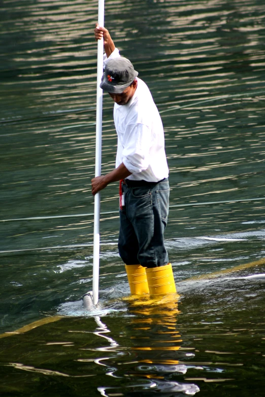 a man standing in some water holding a pole