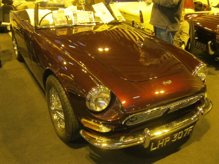 a red and black old model car being displayed