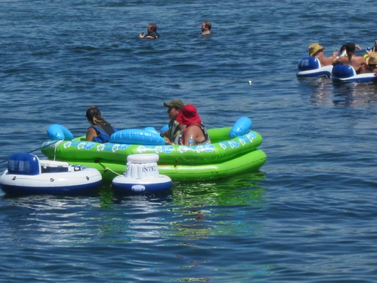 people enjoying on inflatables while floating on the water