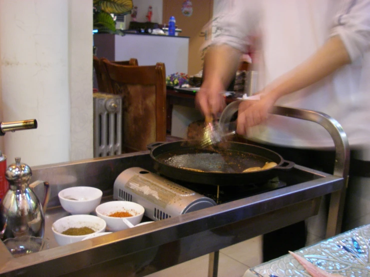 the chef is preparing food on the large pan