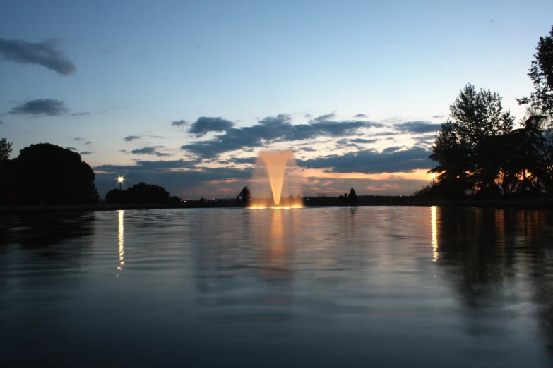 a beautiful water fountain lit by the sun setting