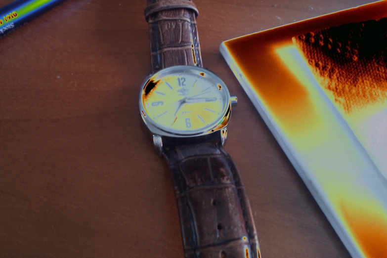 a close up of a watch near a notebook